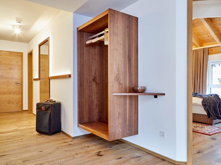 Eingangsbereich der stilvollen Apartment-Suite der Bader-Suites mit Holzfußboden und hochwertigen Holzmöbeln.