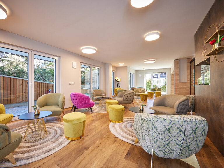 Ein einladender Wohnbereich in den Bader Suites mit schönem Blick aus dem Fenster und gemütlichen Sesseln.