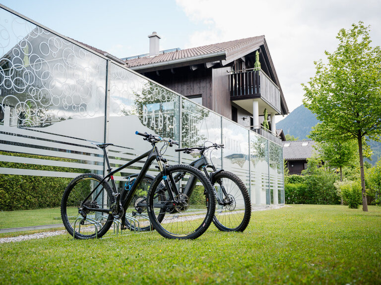Zwei moderne Mountainbikes stehen vor den Bader-Suites in Garmisch-Partenkirchen zur Abfahrt bereit.