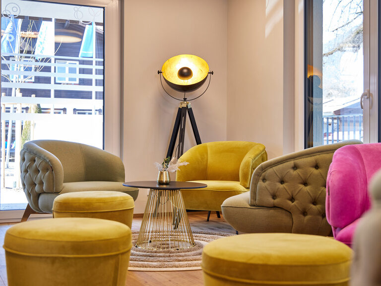 Ein komfortabel eingerichtetes Wohnzimmer der Bader-Suites mit vielen eleganten Couchmöbeln und Sesseln.